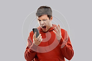 Mad man in red hoodie screaming to smartphone