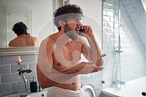 Mad topless man fighting while brushing teeth