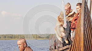 Mad vikings on the Drakkar on the river shore