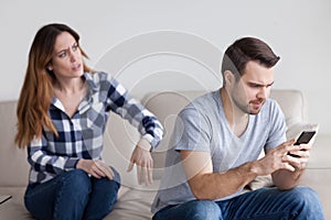 Mad wife talking to indifferent husband busy with phone