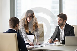 Mad woman showing document mistake to male partner during meetin