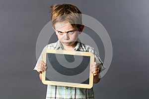 Mad young kid with empty writing slate for sulking attitude