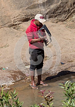 Man washing carparts by hand, getting them ready to sell