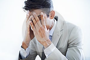 He made a dreadful deal. Closeup of a businessman sitting with his face in his hands.