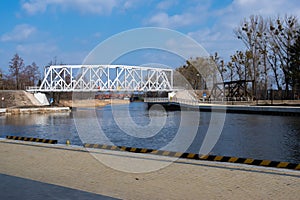 White railway bridge over the river against the background of blue sky. photo