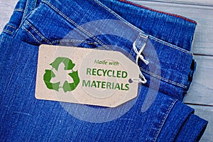 Made with recycled materials label on jeans with eco clothes icon