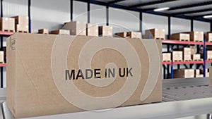 Made in UK import and export concept. Cardboard boxes with product from United Kingdom on the roller conveyor