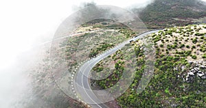 Madeira island, mountain road through the clouds with cliffs and beautifull nature surrounded on a sunny misty day in