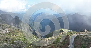 Madeira island, mountain road through the clouds with cliffs and beautifull nature surrounded on a sunny misty day in