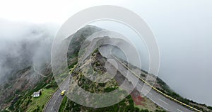 Madeira island, mountain road through the clouds with cliffs and beautifull nature surrounded on a sunny misty day in