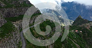 Madeira island, mountain road through the clouds with cliffs and beautifull nature surrounded on a sunny misty day in