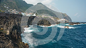 Madeira Island. Picturesque rocky coastline of volcanic lava with frothy surf. Copy space.
