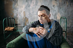 Madman in uniform with plasters on face and hands