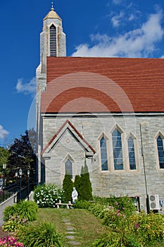 Madonna and Child with church windows, bench, flowers, stone path