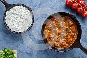 Madras butter Beef spicy slow cook lamb food with rice and tomatoes in cast iron pan