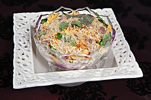 madras mixture. kara boondi in glass bowl garnished with curry leaves.