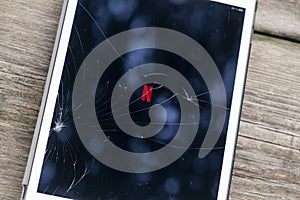 Madrid, Spain. 03-07-2023: Cracked screen of an ipad with the Netflix logotypo