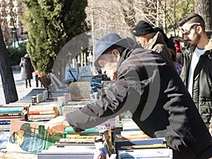 Old men flipping through books Antique Book Store in Moyano`s sl