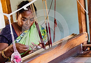 Woman weaves fabric on a traditional loom