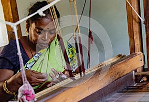 Woman weaves fabric on a traditional loom