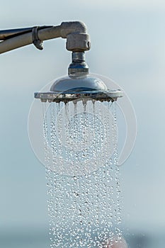 Mage of a vintage old shower head splashing water close up background. Water flows from the head of an old shower. Background for