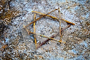 Magen David from tree branches on the ground in memory of the victims Jews during the Holocaust photo