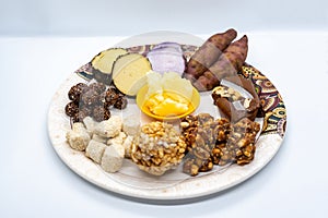 Maghe Sankranti Makar Festival Celebration Food Plate of Muri Ladoo, Sesame Ladoo, Yam, Sweet Potato, Jaggery, Peanuts Ladoo Ghe