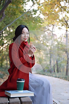 Magic autumn,Fall woman happy and bliss , Beautiful woman Sitting on a bench in autumn park