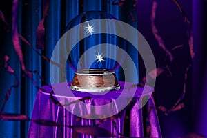 Magic Ball Fortune Teller on Table Covered Violet Cloth Near Red Serpentine And Blue Curtains, 3d rendering., Copy Space