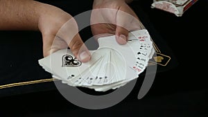 Magic, card tricks, gambling, casino, poker concept - man showing trick with playing cards