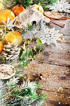 Magic Christmas background - vintage wood, candy cane, house, cinnamon, star anise, sweet mandarins with green leaves