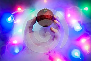 Magic christmas concept. A strange levitated Christmas ornament flies away from a man`s hand.