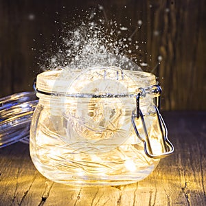 Magic Christmas garland with bright lights inside a glass jar