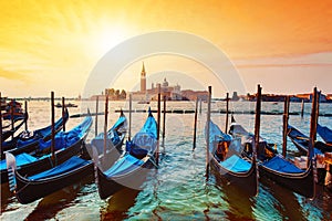 Magic cityscape with gondolas on the San Marco canal on the background of Church of San Giorgio Maggiore at sunset in Venice,