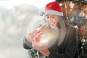 Magic, glow and girl with gift on Christmas in home with surprise in box on vacation or holiday, Excited, woman and