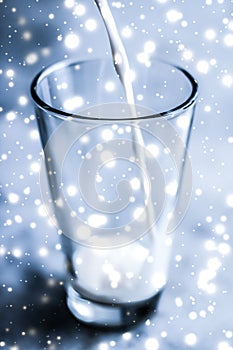 Magic holiday drink, pouring organic lactose free milk into glass on marble table