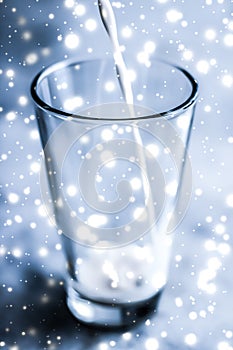 Magic holiday drink, pouring organic lactose free milk into glass on marble table