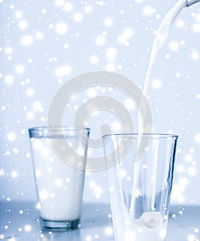 Magic holiday drink, pouring organic lactose free milk into glass on marble table