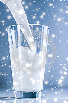 Magic holiday drink, pouring organic lactose free milk into glass on marble table