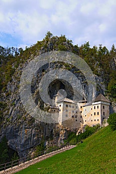 Magic landscape of medieval Predjama castle Slovene. Predjamski grad. Renaissance castle built within a cave mouth photo