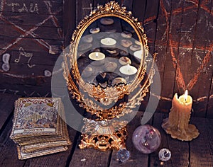 Magic mirror with Tarot cards and burning candles