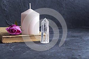 Magic vintage still life with crystals, pink candle, old book and rose flowers. Meditation reiki. Ritual for love and chakra