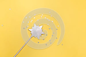 Magic wand on yellow background with stars, glitter spangles. New year and Christmas concept