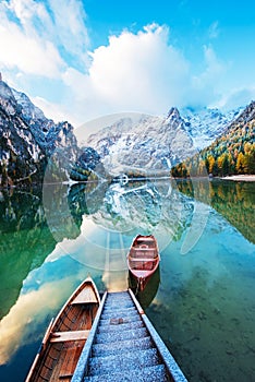 Magical autumn landscape with boats on the lake on Fanes-Sennes-Braies natural park in the Dolomites in South Tyrol, Alps, Italy