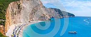 Magical blue bay and strip of beach with white sand against backdrop of rocks. Summer holidays on Greek islands