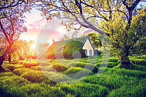 Magical charming beautiful landscape with turf roof church in old Iceland traditional style and mystical cemetery in Hof,