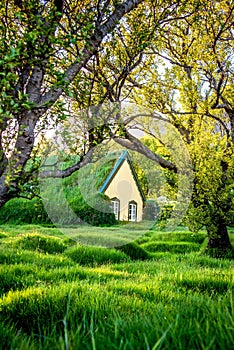 Magical charming beautiful landscape with turf roof church in old Iceland traditional style and mystical cemetery in Hof,