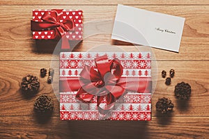 Magical christmas theme background, present, pine cones and christmas card on wooden table
