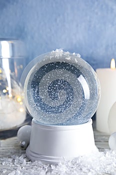 Magical empty snow globe with Christmas decorations and candles