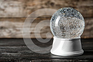 Magical empty snow globe on wooden table.